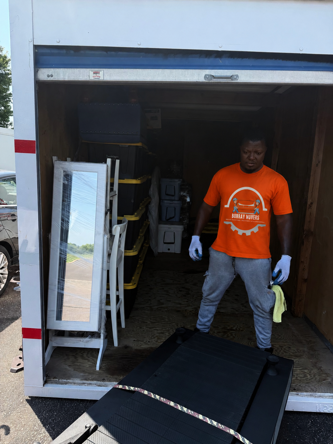 Burray Movers team member in an orange Burray Movers shirt loading a moving truck